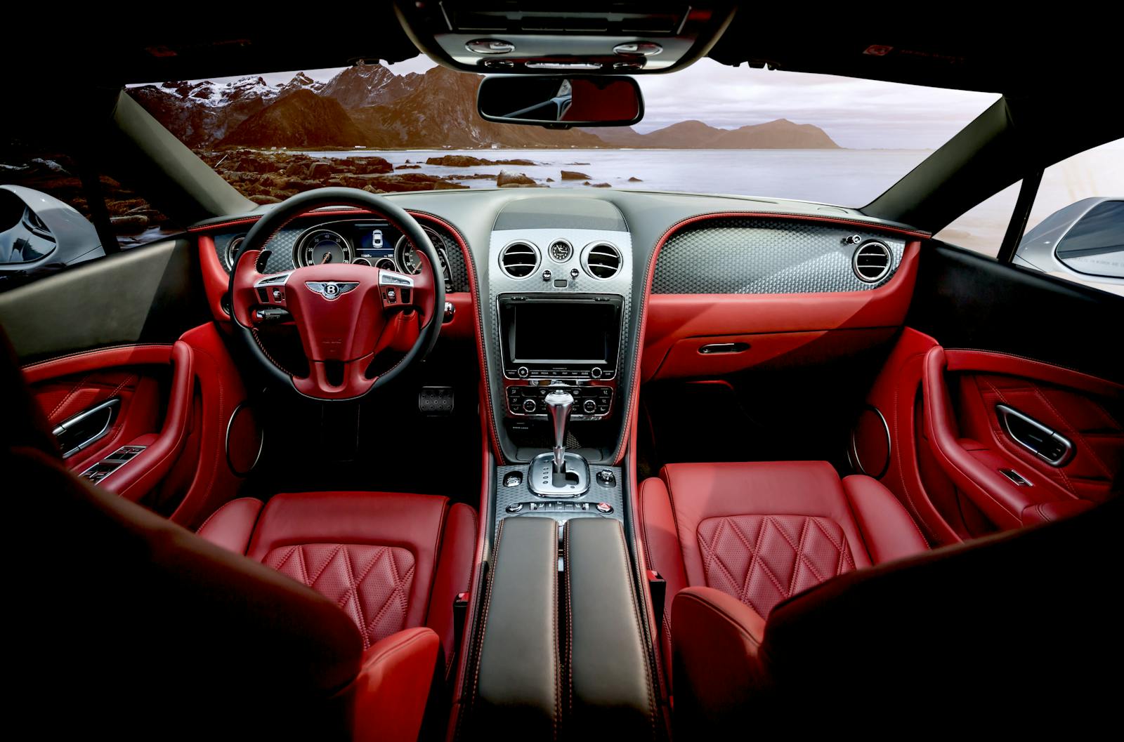 Red leather luxury sports car interior with mountain backdrop outside the window.